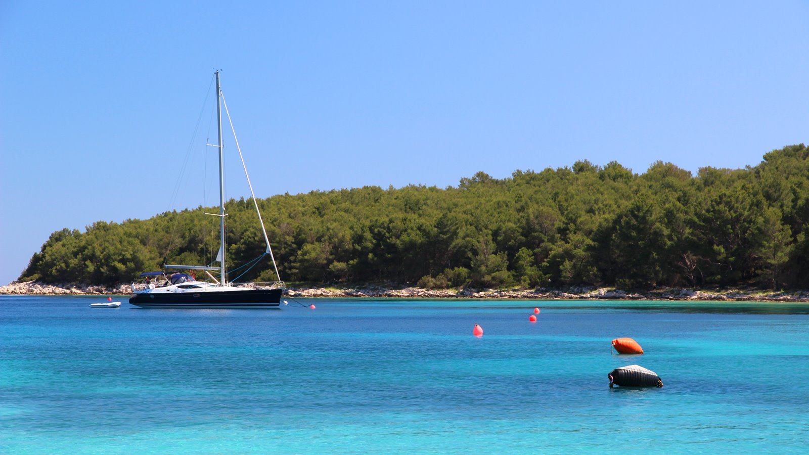 Segelyacht in einer Bucht mit türkisblauem Wasser